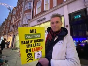Chris Packham of Wild Justice holds a sign asking if Waitrose are really taking the lead on lead?